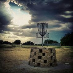 a satellite dish sitting on top of a pile of bricks in the middle of a field