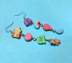 two pairs of earrings made out of polymer beads with charms attached to them on a blue background