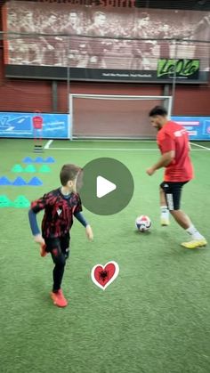 two young boys playing soccer on an indoor field