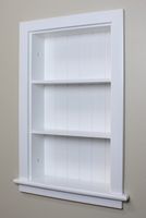 an empty white shelf in the corner of a room