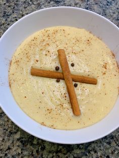 a white bowl filled with batter and cinnamon sticks