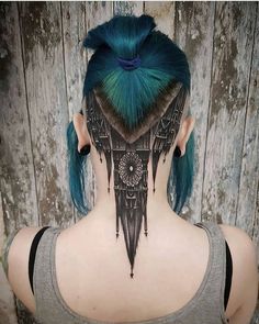 the back of a woman's head with blue hair and tattoos on her neck