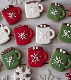 christmas cookies decorated like cups and snowflakes on a white wooden table with red and green frosting