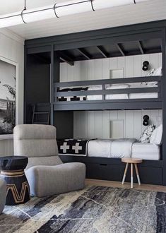 a bedroom with bunk beds and chairs in it