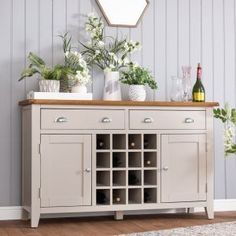 a sideboard with wine bottles and vases on it