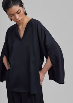 Color: Black Lightweight fluid fabric Relaxed fit V neckline Split dolman sleeves Slip on style Unlined 100% Acetate Machine Wash Cold By Malene Birger. Imported Elegant Silk V-neck Tunic, Chic Oversized Formal Top, Chic Viscose Top With Split Neck, Chic Viscose Tops With Split Neck, Silk V-neck Top With Blouson Sleeves, Chic Silk V-neck Blouse, Silk Top With Draped Sleeves For Work, Silk Tops With Draped Sleeves For Work, Black Split Neck Top For Summer