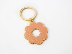 a pink and gold keychain with a doughnut in the shape of a circle