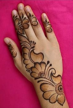 a woman's hand with henna tattoos on it