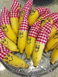 a bunch of bananas with faces drawn on them in checkered red and white cloths