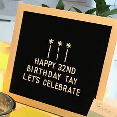 a birthday card with candles and a lit candle on the table in front of it