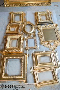 there are many gold frames on the table