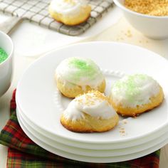 there are three cookies on the plate with green icing and sprinkles