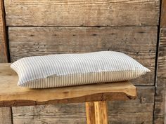 a pillow sitting on top of a wooden bench