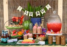 an assortment of food and drinks displayed on a table in front of a bamboo wall