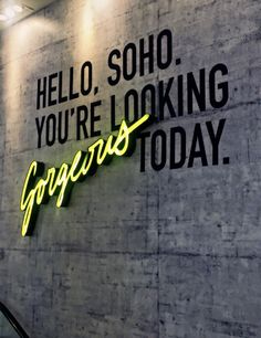 a neon sign on the side of a building that says, hello, soho you're looking gorgeous today