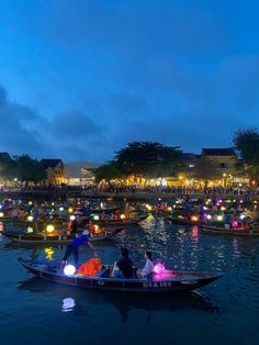 people in boats with lanterns floating on the water