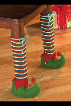 two legs with christmas stockings tied to them, standing on top of a wooden table