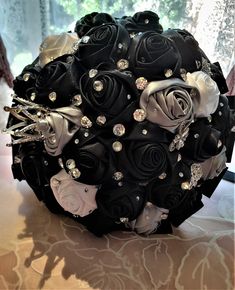 a bridal bouquet made up of black roses and diapered brooches