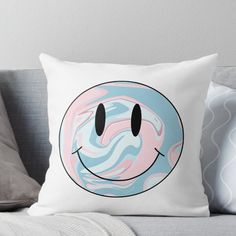 a smiley face with pink, blue and white swirls on it's pillow