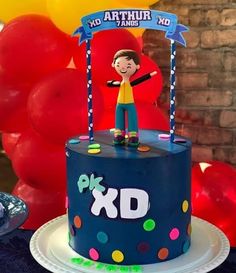 a birthday cake with an image of a boy on top and balloons in the background