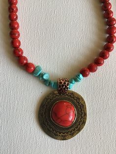 Red coral and turquoise colors necklace, cooper pendant. Red Bohemian Necklace With Large Pendant, Red Coral Pendant Necklace, Red Beaded Pendant Necklace, Red Bohemian Round Pendant Jewelry, Unique Red Necklace With Large Pendant, Red Medallion Necklace With Large Pendant, Red Beaded Pendant Necklace With Natural Stones, Red Amulet Pendant Necklace, Unique Red Copper Necklace