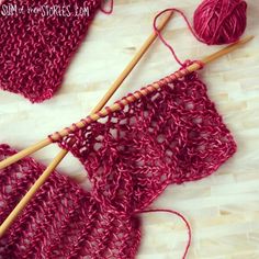 two knitting needles are next to a crocheted piece of cloth with yarn on it