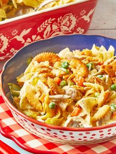 a bowl filled with pasta and vegetables on top of a red checkered table cloth