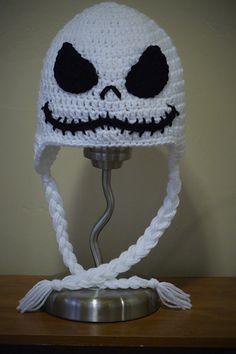 a crocheted skull hat on top of a metal stand