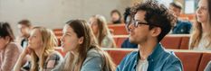 a group of people sitting next to each other in front of a classroom full of students