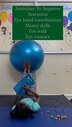 a young child is playing with a large blue ball and some balls on the ground