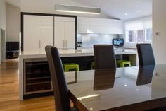 a modern kitchen and dining room with wood floors