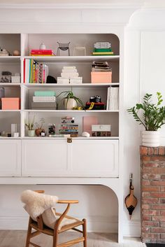 a white bookcase filled with books next to a fireplace