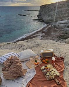 there is a picnic on the beach with food and drinks laid out in front of it