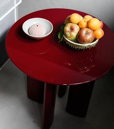 a bowl of fruit sitting on top of a red table