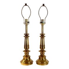 a pair of brass candlesticks with rings on the top and bottom, both turned upside down