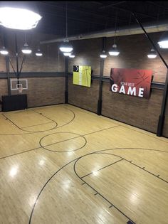 an indoor basketball court with lights on the ceiling and wood flooring in front of it