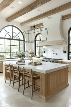 a large kitchen with an island in the middle and lots of windows on both sides