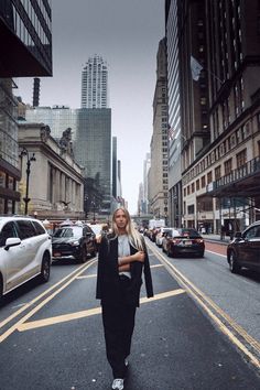 a woman standing in the middle of an empty street