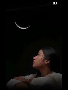 a woman is looking up at the moon