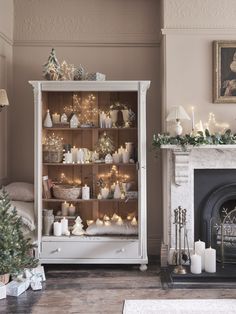 a living room filled with furniture and a fire place next to a fireplace covered in christmas decorations