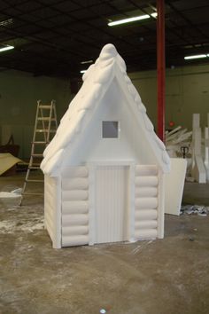 a white house made out of foam in a garage