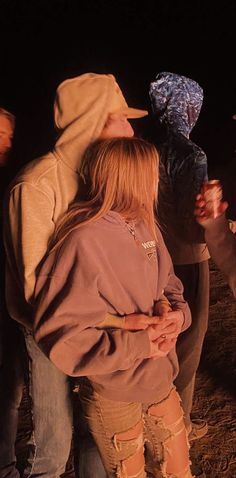 two people standing next to each other in the dark