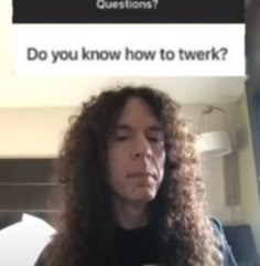 a man with long curly hair is looking at his cell phone and has the question do you know how to twirk?