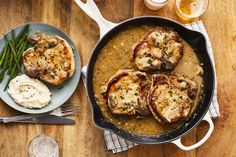 some meat and gravy in a skillet on top of a wooden table