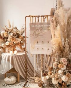 a table topped with lots of flowers next to a tall sign that says our wedding date