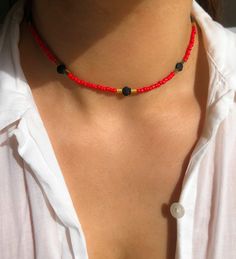 BEACHCOMBER (red) Elevate your style with our exquisite "Beachcomber" Red Beaded Choker Necklace, a statement piece that exudes glamour and sophistication. This stunning necklace features matte black hematite gemstones in seashell shapes, accented with gold hematite for that touch of luxury. The name "Beachcomber" conjures images of strolling along the shore, collecting treasures from the sea. This necklace captures that essence perfectly, with its unique design inspired by the beauty of seashel Black Beads Summer Beach Jewelry, Summer Beach Jewelry With Black Beads, Summer Spacer Bead Choker Jewelry, Summer Festival Jewelry With Black Beads, Adjustable Black Beaded Necklace For Summer, Adjustable Black Beads Jewelry For Beach, Adjustable Black Beaded Jewelry For Beach, Adjustable Red Beaded Necklace For Beach, Adjustable Red Beaded Necklace With Black Beads