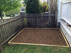 a backyard area with gravel and wooden fence