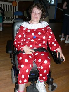 a woman in a red and white polka dot outfit sitting on a wheel chair