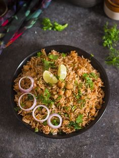 a bowl filled with rice, onions and cilantro on top of a table