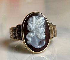 Gorgeous genuine hand carved dark hard-stone cameo ring of wonderfully detailed bearded man with a cap who appears to be Leonardo DaVinci from the late 1700s to early 1800s Georgian period. Hand wrought band has stunning ornate etching on shoulders with a beautiful organic floral design. This is a natural hard-stone cameo that was hand carved. The cameo is nicely carved and in good antique condition. Ring weighs 2.7 grams. The details: The hand carving in this piece is fine quality and very deta Antique Cameo Signet Ring Collectible, Three Rings, Cameo Ring, Ring Antique, Precious Gems, Ring Gold, Antique Rings, Sell Items, Signet Ring